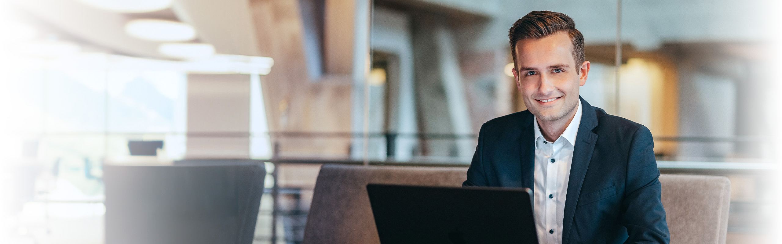 Leon Grage, SEO-Freelancer und Online-Marketing-Berater aus Ibbenbüren, lächelnd am Laptop